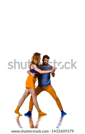 Skillful hip-hop dancers in movement. Young couple of modern dance dancing on studio background
