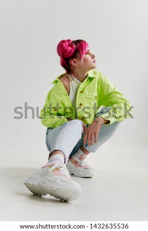 woman in green jacket with white sneakers sitting
