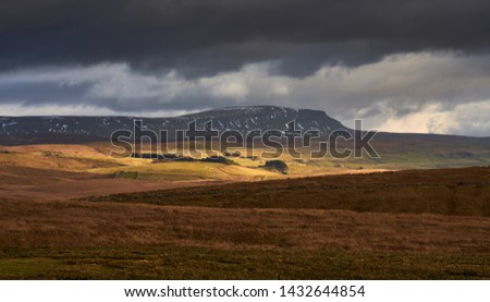 Storm clouds and sunshine over the Three Peaks Summit of Pen-y-ghent near Horton in Ribblesdale in the Yorkshire Dales, England. Royalty-Free Stock Photo #1432644854