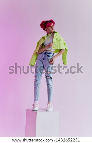 a woman with pink hair stands in a neon cube spotlight fashion