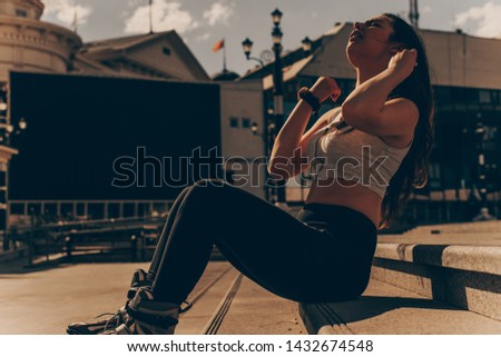 Young brunette woman is rollerblading on a city square, low key, dark