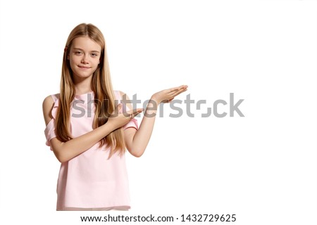 Studio portrait of a beautiful girl blonde teenager in a pink t-shirt posing isolated on white background.