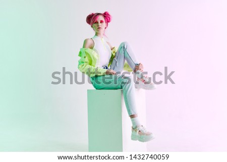woman with pink hair  sits on the cube