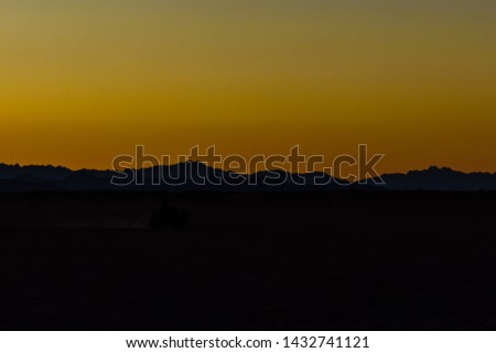 Unrecognizable man driving quad bike during safari trip at sunset in Arabian desert not far from Hurghada city, Egypt