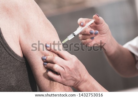 Doctor injecting vaccine in arm of patient