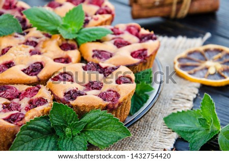 American muffins with cherry and lemon and mint leaves. Delicious dessert.