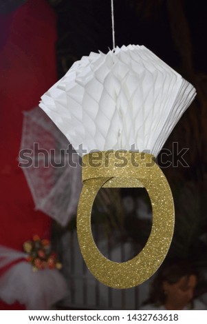 paper garland in the form of a gold ring with a white diamond, white inflatable balls hanging at night outside the house at night, wedding party