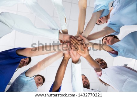 Low Angle View Of Doctor Stacking Hands Together In Hospital Royalty-Free Stock Photo #1432770221