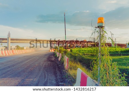 Alarm lights for the construction of a car bridge across the irrigation canal in the evening. Selective focus on alarm lights.