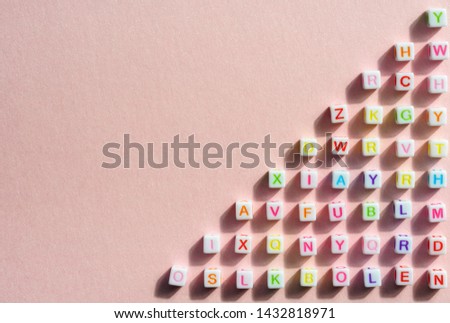 Colorful alphabetical cubes on pink bright background 