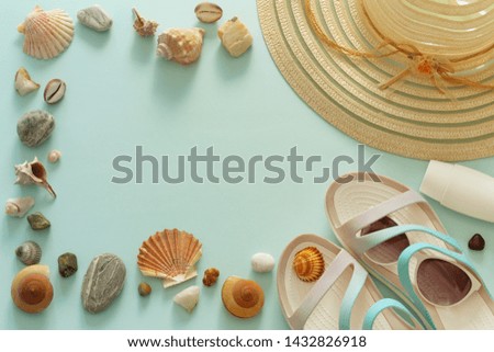 a holiday photo, a summer hat, beach sandals, sunscreen, sun glasses, scallops and souvenir pebbles.  Empty space for an inscription