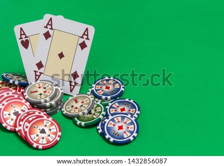 poker chips stack and playing cards on green table. empty space for text and design. two aces