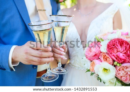 newlyweds clink glasses at the wedding. Newlyweds touched glasses of champagne.