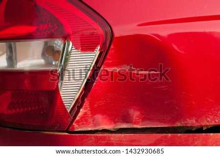 tail light car. broken rear brake light. red passenger car. dent and scratch on the rear fender. road accident