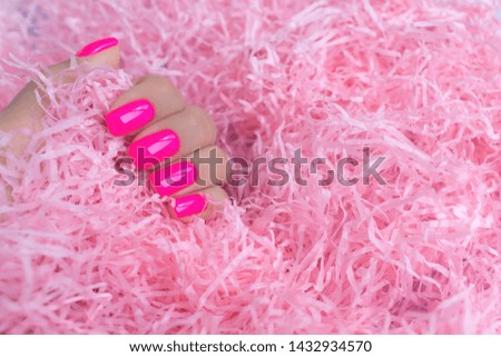 Stylish trendy female manicure. Neon plastic pink nails on confetti background. 
 Nail polish. Art manicure. Modern style.