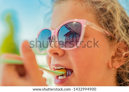 The girl is sunbathing, resting on the swing, eating honey and drinking a cocktail