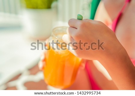 The girl is sunbathing, resting on the swing, eating honey and drinking a cocktail