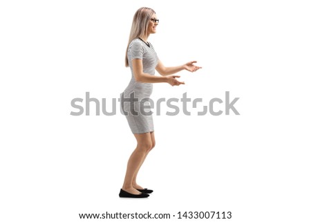 Full length profile shot of a young woman waiting to catch something isolated on white background