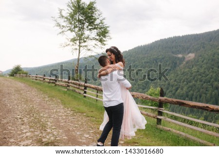 Groom kiss his beautiful bride. Couple walking in mountains