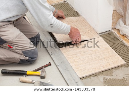 a tiler laying a tiled marble Royalty-Free Stock Photo #143303578