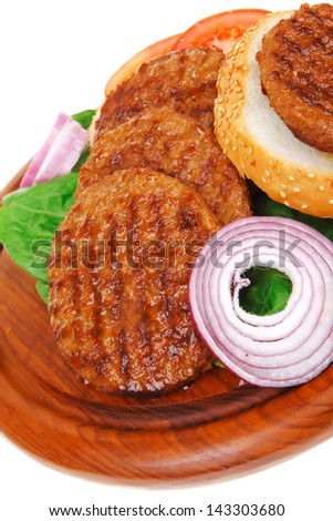 several large roast hamburger with loaf on wooden plate isolated over white background