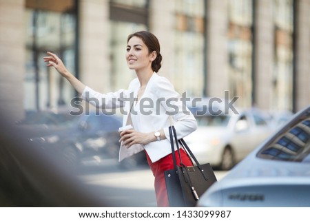Waist up portrait of beautiful woman hailing taxi in rush hour in city center, copy space