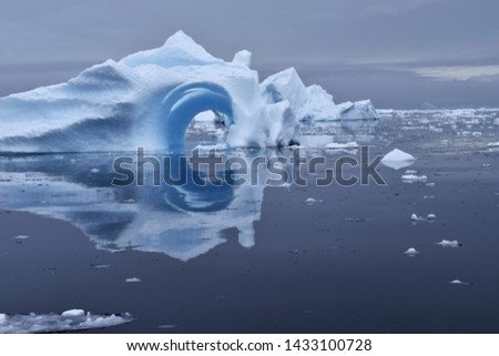 Circular water reflection of an iceberg in Antarctica