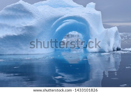 Hollowed Iceberg reflection in the icy waters of Antarctica