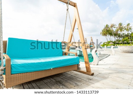 empty sofa swing with tropical Maldives resort and sea background - vintage effect filter