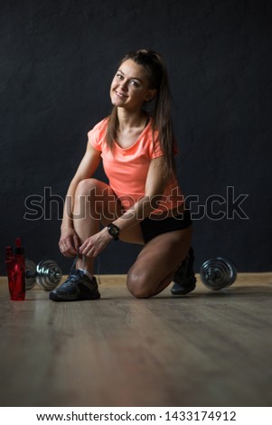Attractive fitness caucasian woman, trained female body. Lifestyle portrait on black wall