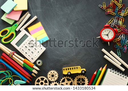education and back to school concept. stationery and bus over classroom blackboard. top view, flat lay
