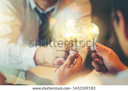 Sharing idea for help concept, Colleagues sharing a light bulb of idea Royalty-Free Stock Photo #1433189183