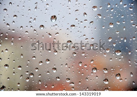 rain drops on window against buildings 