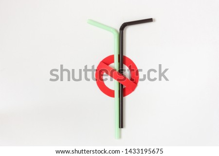 Stop using plastic straws. A creative artwork of prohibition sign over colorful plastic straws on white background. Environmental/pollution concept. Top view.