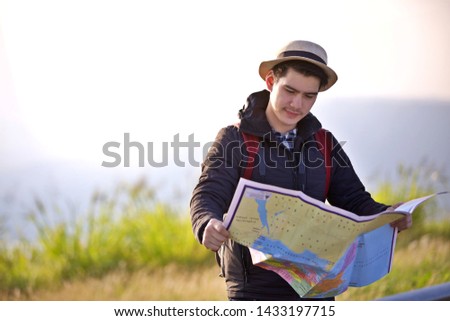 Asian men traveler hand up relax with backpack looking at amazing mountains and forest, travel holiday relaxation concept