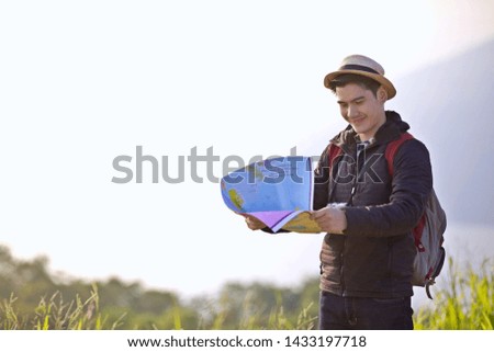 Asian men traveler hand up relax with backpack looking at amazing mountains and forest, travel holiday relaxation concept