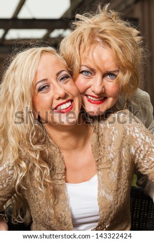 Pretty blonde fashion mother and daughter outdoor in urban environment.