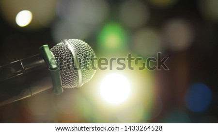 Leadership improvement or Enjoy music theme microphone on blurred background of stage with lighting effect or live recording studio with bokeh defocused lights. (selective focus, space for text)