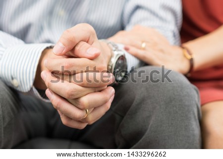 Close up: Hands of worried husband, his wife reaching out his arms to support comfort him. Marriage life concept - Love, Compassion, Relationship, Sympathy, Caring, Apology, Forgiveness, Affectionate.