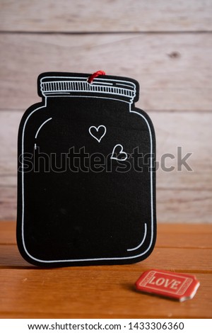 Black wooden tag decorate with small love sign on the wooden background. Simple and minimal style for and advertising, business and commercial usage. Copy space for text. Love photo concept.