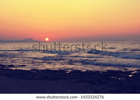 Colorful background and concept for travel and summer vacation. Beautiful sunset by the sea. Mediterranean Island of Crete - Greece. 
