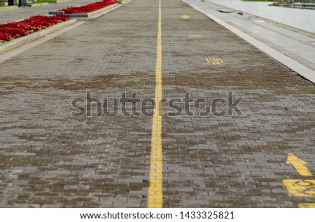 a sidewalk with a yellow stripe after the rain