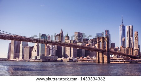 Famous Skyline of downtown New York City, Brooklyn Bridge and Manhattan with skyscrapers illuminated over East River panorama. New York, USA