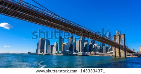 Famous Skyline of downtown New York City, Brooklyn Bridge and Manhattan with skyscrapers illuminated over East River panorama. New York, USA