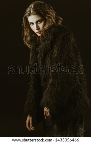 A portrait of a beautiful gorgeous girl in black posing in the studio over the black background. Beauty, fashion.