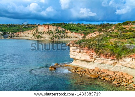 Stony coast washed by sea water in Malta. Sea landscape. The concept of tourism and recreation on the coast.