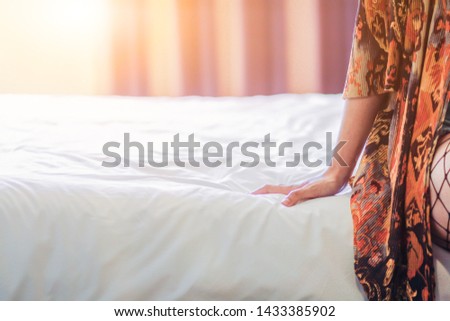 The girl is waking up from sleep in bed in the morning with lazy and looking at the sunrise outside the window in the morning on the weekends,with a refreshing, relaxing mood in the morning