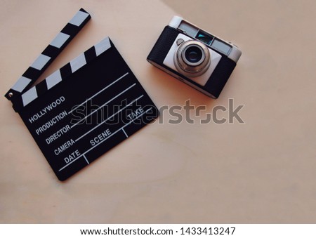 White background with a movie clapboard and a camera.