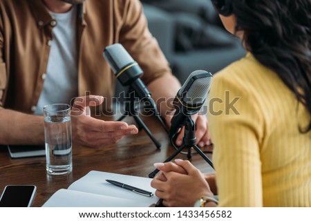 cropped view of two radio hosts recording podcast in broadcasting studio Royalty-Free Stock Photo #1433456582