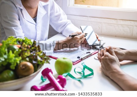 Nutritionist giving consultation to patient with healthy fruit and vegetable, Right nutrition and diet concept Royalty-Free Stock Photo #1433535833
